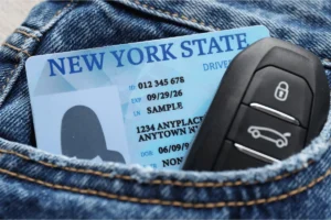 Image of New York State ID in a back jean pock with car keys for a NY motorist facing unlicensed operation arrest.