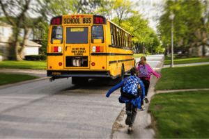Two elementary school children get on the bus to school on an Orange County NY road.
